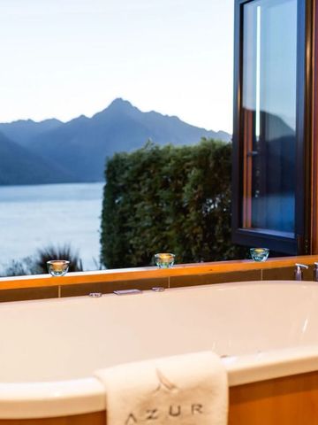 Freistehende Badewanne mit Ausblick auf Bergsee