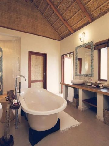 Luxuriöses Bad mit freistehender Wanne und Mosaik-Duschwand auf Benguerra Island