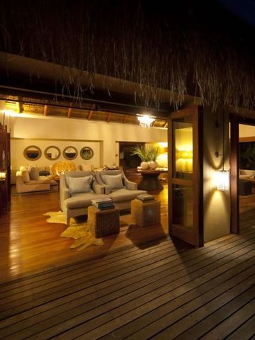 Gemütlicher Wohnbereich einer Villa bei Nacht mit offenem Zugang zur Terrasse