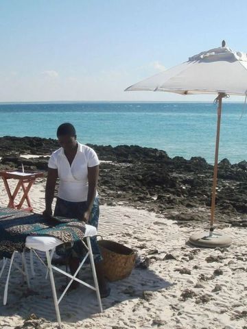 Frau bereitet Massagebereich am Strand vor