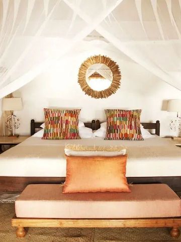 Luxuriöses Schlafzimmer mit Himmelbett und stilvoller Dekoration im Hotel Azura Quilalea