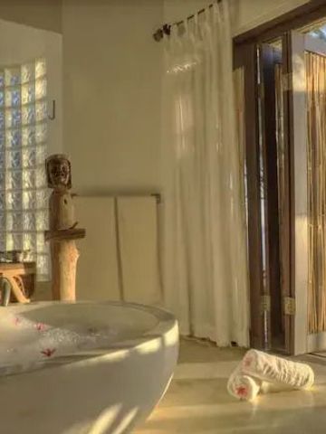 Luxuriöses Badezimmer mit freistehender Badewanne und Blick auf das Meer