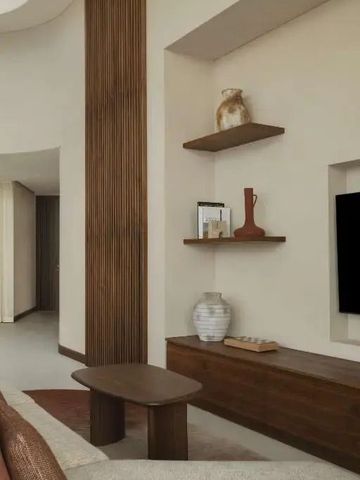 Moderner Wohnbereich mit Fernseher und dekorativen Elementen im Hotel Bab Al Shams