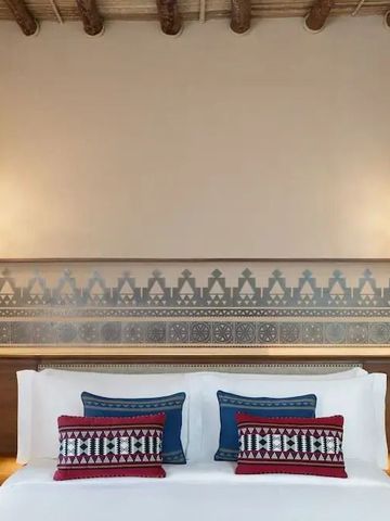 Gemütliches Schlafzimmer mit dekorativen Kissen und Nachttischen