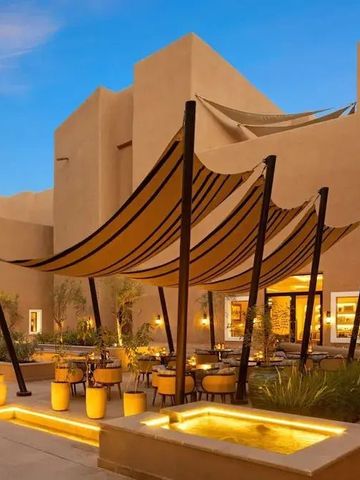 Outdoor-Lounge bei Abendbeleuchtung mit modernen Segeltüchern