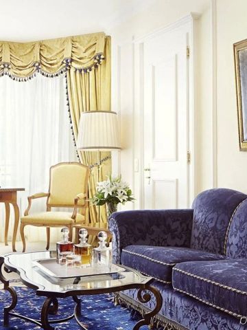 Elegantes Wohnzimmer mit blauen Samtmöbeln und klassischen Details