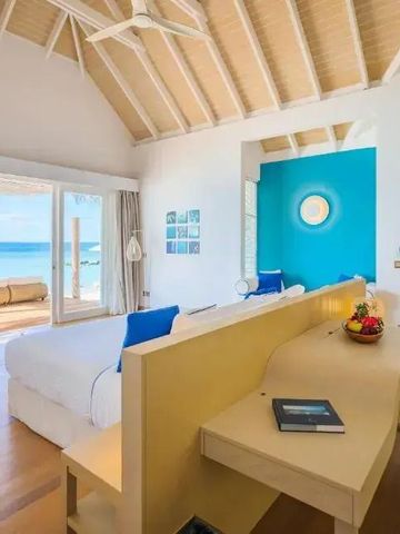 Geräumiges Schlafzimmer mit blauer Akzentwand und Meerblick