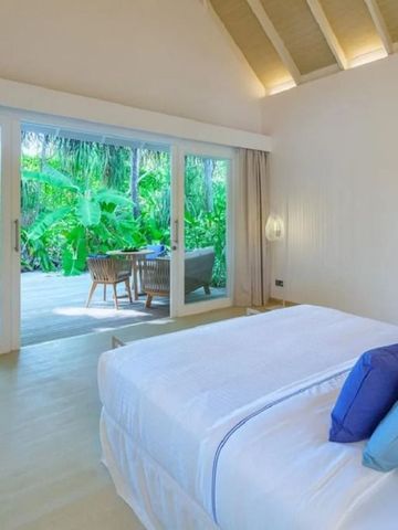 Lichtdurchflutetes Zimmer mit Blick auf eine tropische Terrasse.