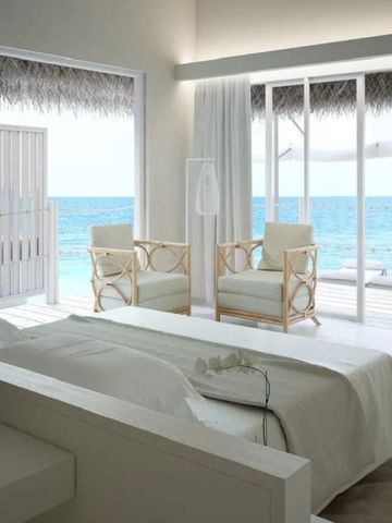 Schlafzimmer mit Blick auf das Meer und gemütlichen Sitzgelegenheiten.