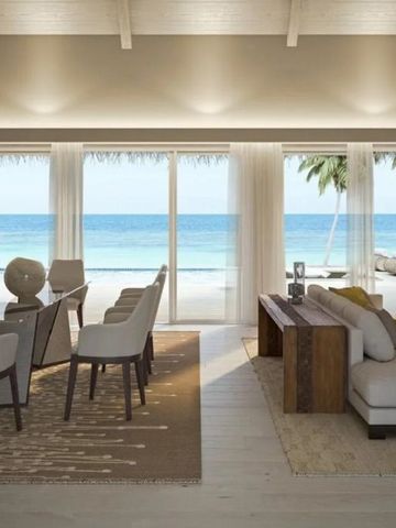 Wohnbereich mit Essplatz und Blick auf den Strand und das Meer.