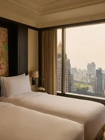 Modernes Doppelzimmer im Banyan Tree Bangkok mit Fensterblick auf die Stadt.