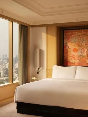 Luxuriöse Hotelsuite mit großen Fenstern und Stadtblick.