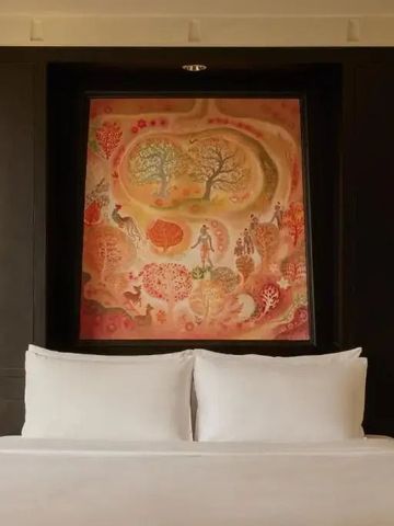 Hochwertige Bettwäsche und Kunstbild in einem stilvollen Hotelzimmer.