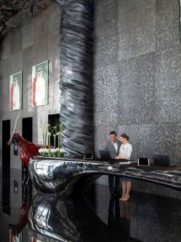 Moderne Hotelrezeption mit polierten Metallelementen und Kunstobjekten