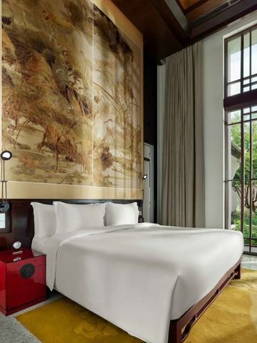 Elegantes Hotelzimmer mit großer Wandkunst und Gartenblick