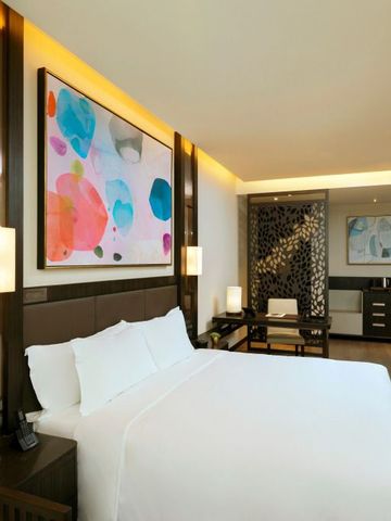 Modernes Hotelzimmer mit großem Bett und Kunst an der Wand