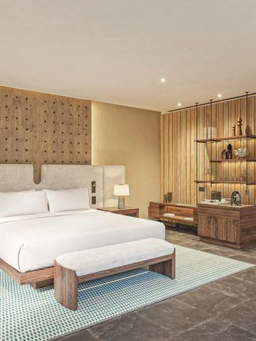 Modernes Hotelzimmer mit Kingsize-Bett, stilvoller Einrichtung und Holzdetails