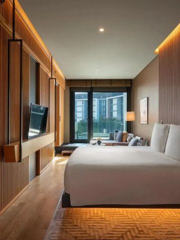 Luxuriöses Hotelzimmer mit modernem Interieur und großem Bett, Blick auf Fensterfront