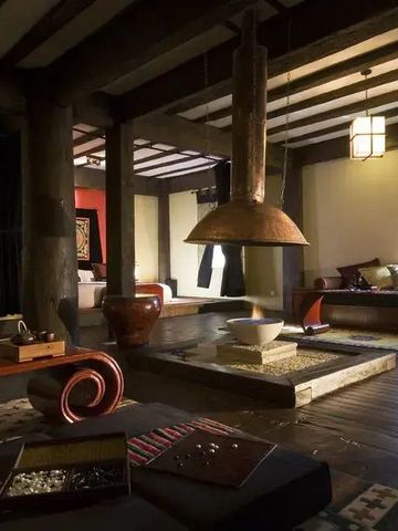 Wohnbereich mit offenem Kamin, traditionellem Dekor und Holzbalken.