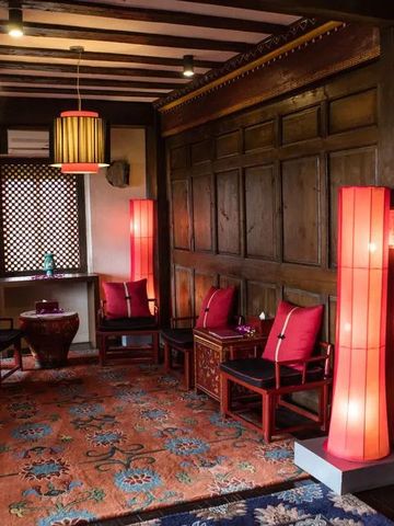 Gemütliche Loungebereich mit Holzwänden und roten Lampen im Hotel Banyan Tree Ringha.