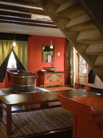 Zimmer im Hotel Banyan Tree Ringha mit freistehender Badewanne und roter Dekoration.