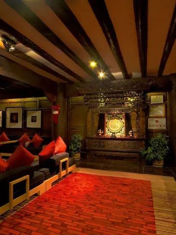 Elegante Lounge im Hotel Banyan Tree Ringha mit traditionellem Dekor und roten Kissen.