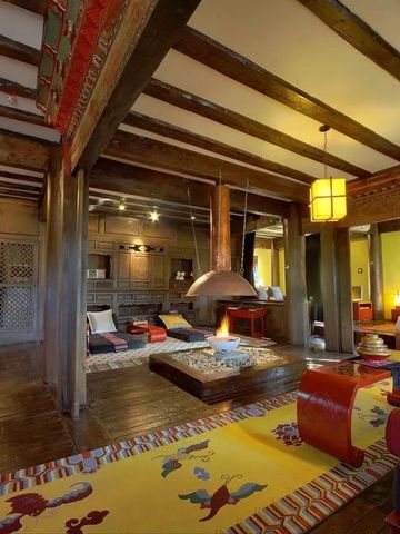 Große Suite im Hotel Banyan Tree Ringha mit gemütlichem Wohnbereich und offener Feuerstelle.