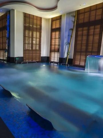 Innenpool mit Wasserfall und stilvollen Jalousien