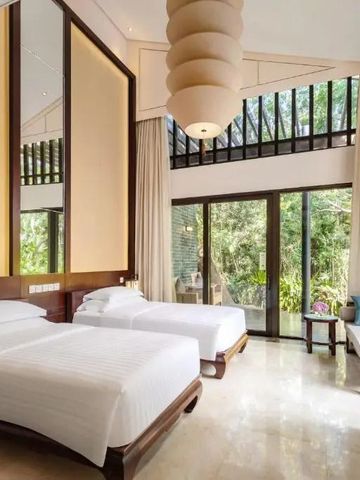 Helles Zimmer mit zwei Einzelbetten und großer Fensterfront zum Garten