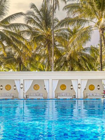 Pool mit balinesischen Liegeplätzen und Palmen