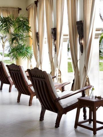 Entspannungsbereich mit Holzstühlen und Vorhängen im Baraza Resort und Spa