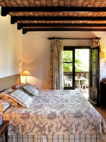 Gemütliches Hotelzimmer mit Holzbalkendecke und Blick auf die Terrasse