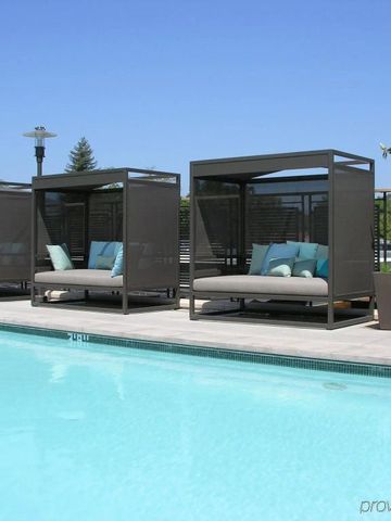 Modern gestaltete Pool-Cabanas mit gepolsterten Liegen und Sonnenschutz
