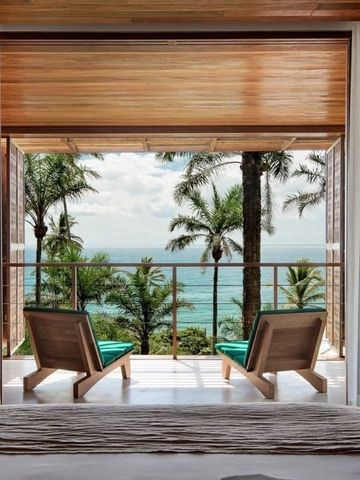 Atemberaubender Meerblick durch geöffnete Türen mit Palmen im Hintergrund.