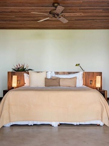 Gemütliches Schlafzimmer mit Doppelbett, Holzdekor und weichen Beleuchtungselementen.