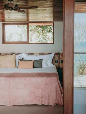 Zimmer mit großem Fenster und Blick auf das Meer, elegantes Interieur mit Holzakzenten.