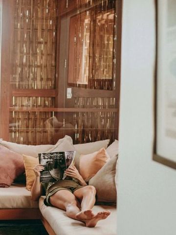 Behagliche Sitzecke in natürlich dekoriertem Raum mit Kissen und rustikalen Elementen