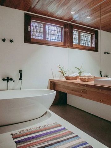 Modernes Badezimmer mit freistehender Badewanne, Holzdetails und natürlichem Licht
