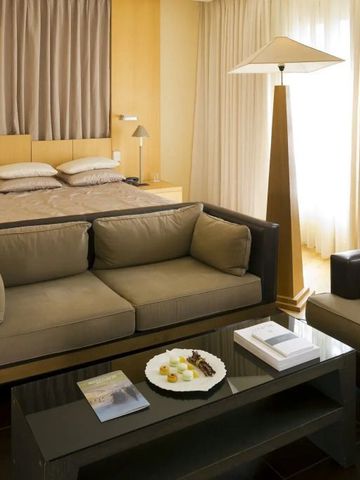 Modernes Wohnzimmer mit stilvoller Kombination aus Sofa und Doppelbett in heller Atmosphäre.