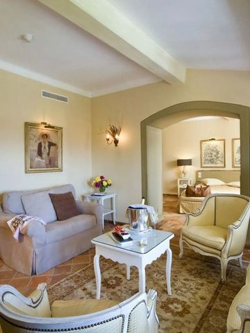 Gemütlicher Wohnbereich mit eleganten Polstermöbeln. Klassischer Stil mit Blumenarrangement.