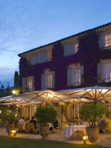 Romantische Abendansicht eines mit Blumen bewachsenen Hotels mit Terrasse