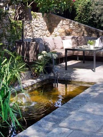 Gemütliche Terrasse mit Wasserbrunnen und bequemer Sitzecke im Garten