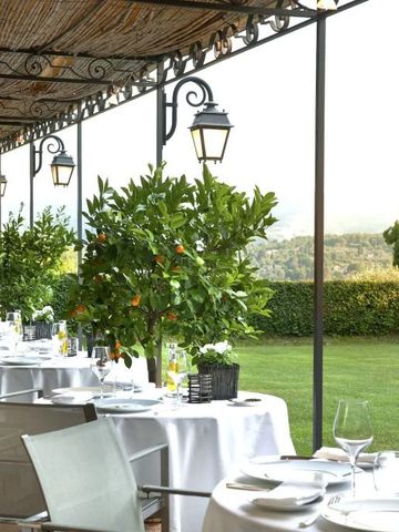 Elegante Restaurantterrasse mit weißen Tischdecken und Blick ins Grüne