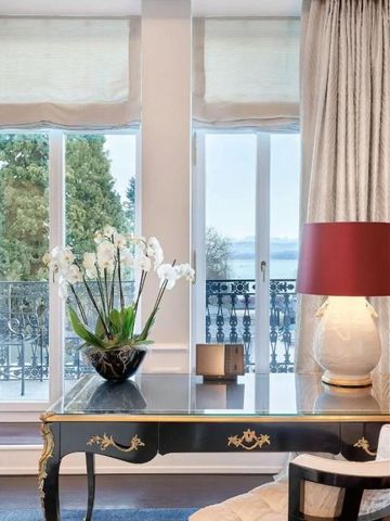 Dekorativer Blick auf einen Tisch mit Lampe und Orchideen vor großen Fenstern