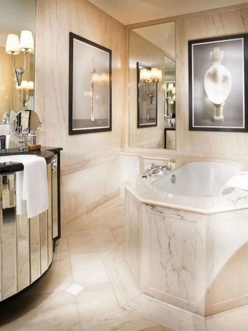 Luxuriöses Badezimmer mit Marmorelementen und großer Badewanne