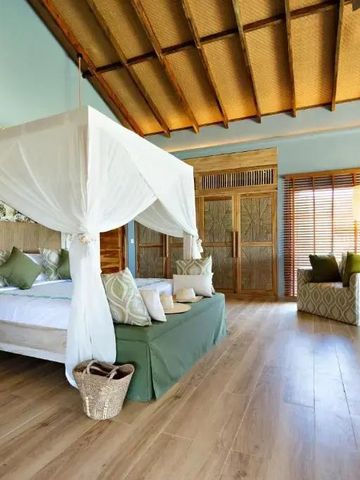 Geräumiges Schlafzimmer mit Himmelbett und Holzboden