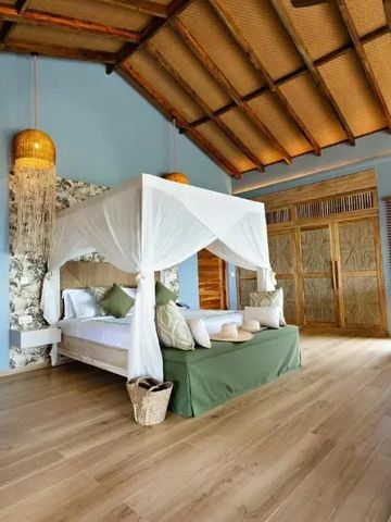 Himmelbett mit weißen Vorhängen in einem hellen Raum