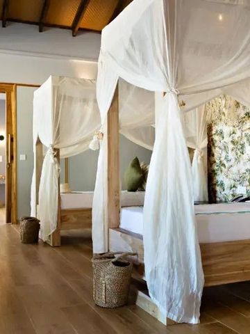 Luxuriös eingerichtetes Schlafzimmer mit Himmelbett und Holzböden