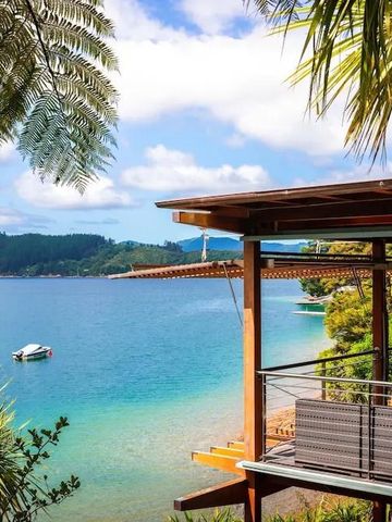 Terrasse mit Blick auf eine ruhige Bucht und umliegende Berge im Sonnenschein