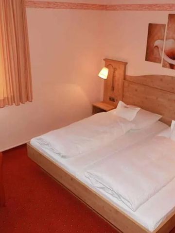 Gemütliches Doppelzimmer mit Holzmöbeln und warmen Farben